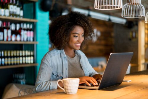A woman using a laptop in a restaurant.